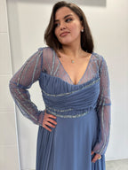Robe de soirée bleu, buste plissé orné de pailettes, col en v et manches longues transparents pailletés