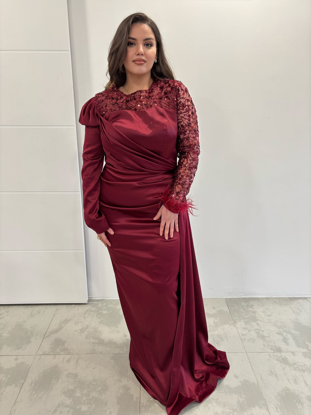 Robe de soirée longue en satin bordeaux, manches longues bi-matières et traine sur le coté 