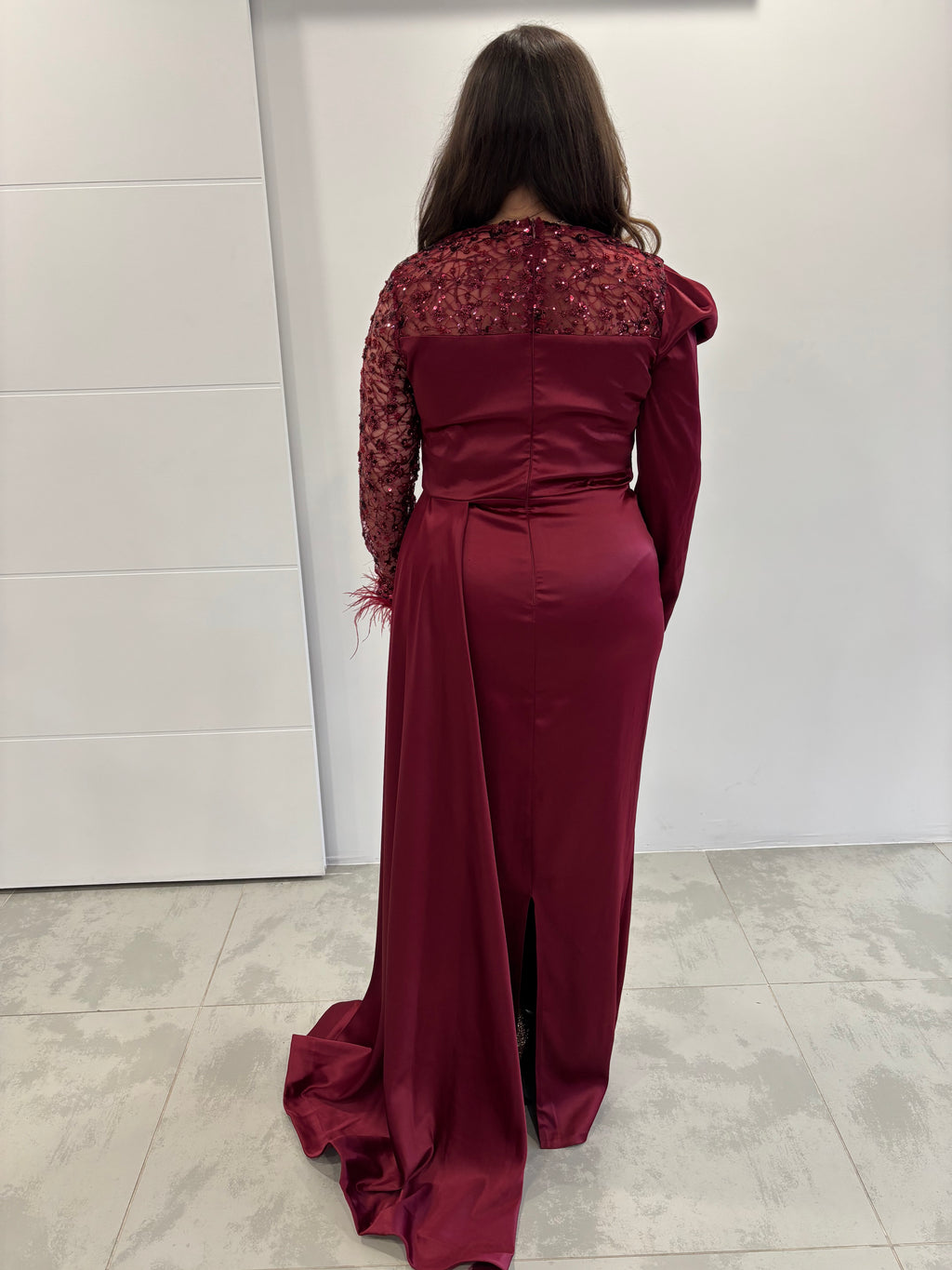 Robe de soirée bordeaux en satin avec traine sur le coté, une manche transparente pailleté et une manche en satin, mini fente au milieu - vue de dos 