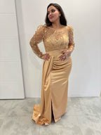 Robe de soirée en satin dorée, manches longues et buste transparents à paillettes, traine et petite fente sur le côté - vue de face 