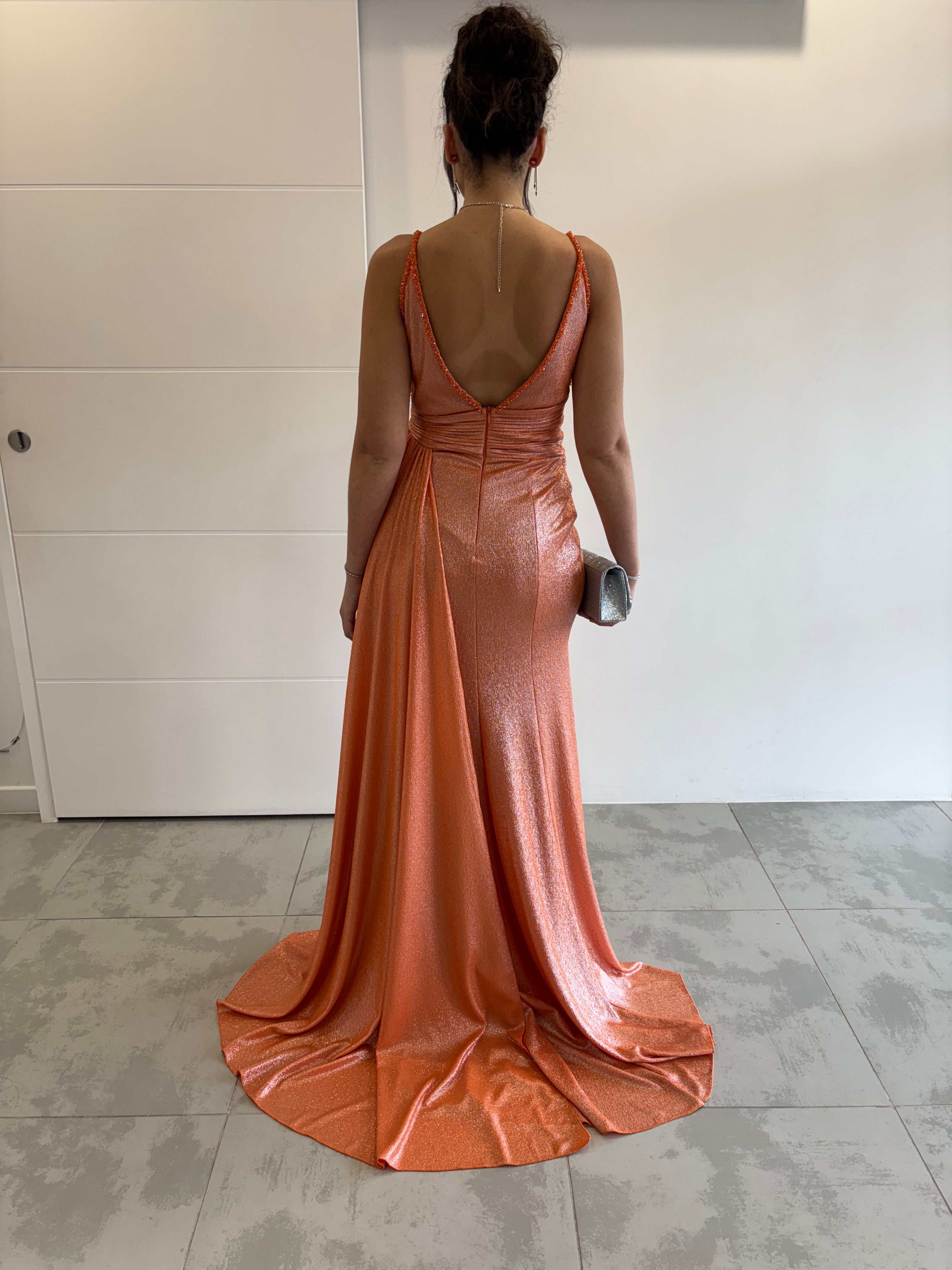 Robe de soirée longue orange pailletée avec fente, bretelles fines, dos en V plongeant et traîne sur le côté