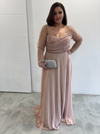 Robe de soirée rose poudrée évasée  vue entière de face, manches longues transparentes pailletées, buste et traine sur le coté plissés 
