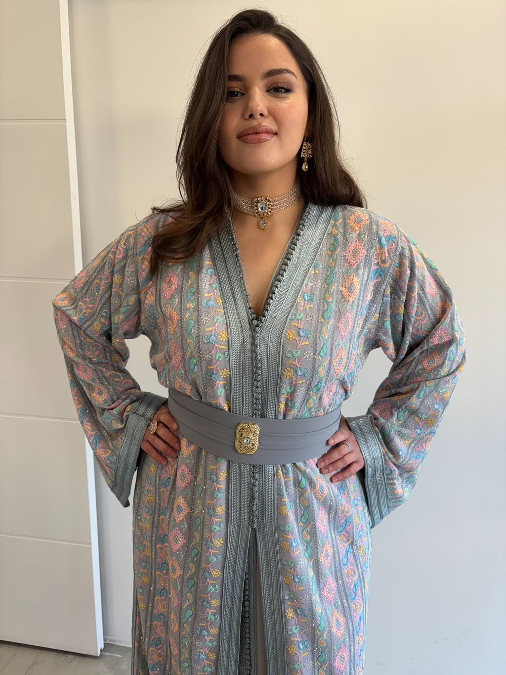 Gros plan sur takchita sari gris clair en location, ceinture en tissu assortie, broderies multicouleurs et strass argentés sur robe orientale de cérémonie