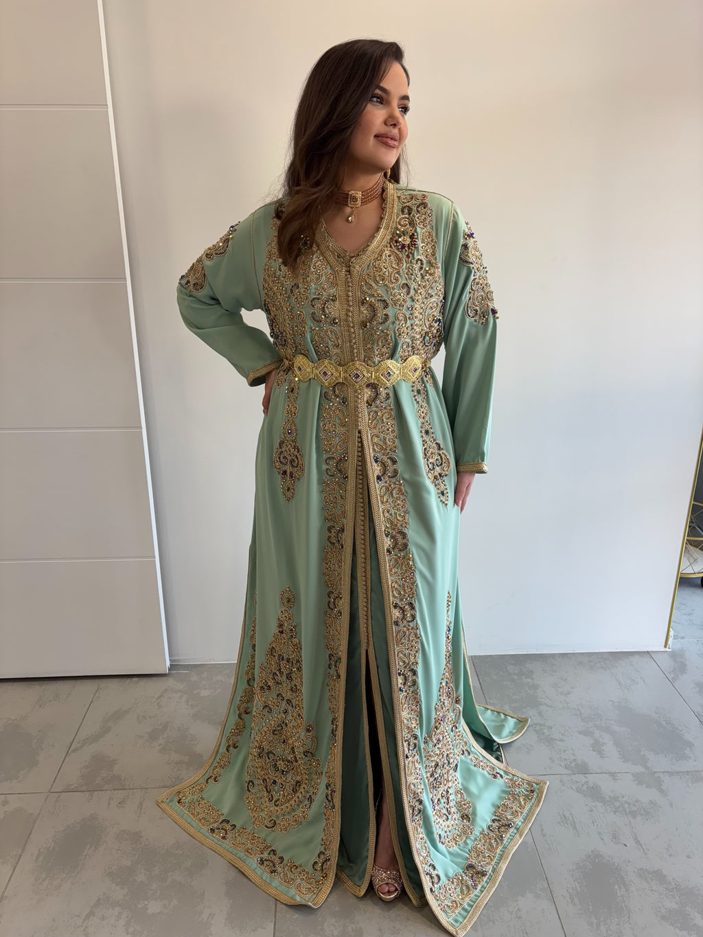 Takchita invitée vert d’eau et doré, perlée et chargée, en location pour mariage